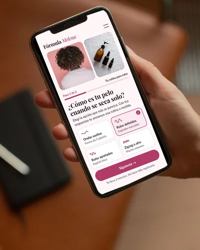 Landing de una marca de cuidado del pelo con cuestionario abierta en un celular que sostiene una mano